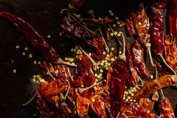 Whole dried chilli peppers with seeds lying in sunlight beam