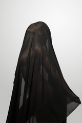 Girl in a black transparent veil on the face. Conceptual portrait in the studio. Minimalism.