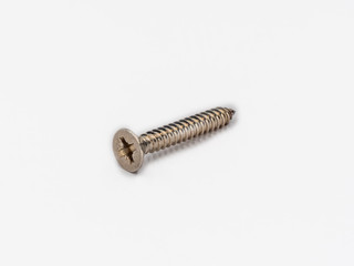 Cross recessed inox tapping screw, flat head shot on white.