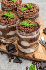 Classic tiramisu dessert in a glass on dark concrete background