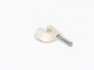 White plastic cable clip nail shot on white.