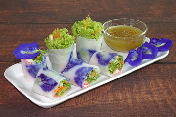 Spring rolls : Edible flowers spring rolls. Beautiful and delicious Thai cuisine, made from butterfly pea flowers, carrot, and vegetables wrapped with rice paper, served with lemon and chili sauce