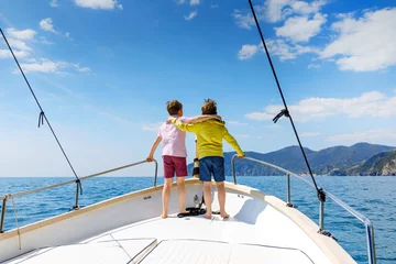 Foto auf Acrylglas Two little kid boys, best friends enjoying sailing boat trip. Family vacations on ocean or sea on sunny day. Children smiling. Brothers, schoolchilden, siblings having fun on yacht. © Irina Schmidt