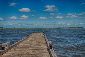 Fototapeta premium Old rickety wooden jetty leading into a lake