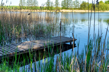 Old rustic wooden jetty on a tranquil lake