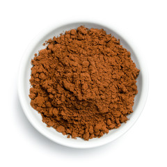 Cocoa powder in a white ceramic bowl isolated on white from above.