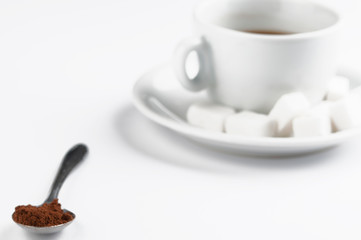 White coffee cup with sugar cubes  and metal spoon isolated on white background.