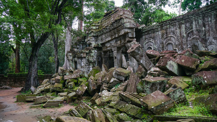 Ruined architectural heritage of Ta Phrom ancient temple complex with old scattered stones and rock. (Angkor Wat, UNESCO World Heritage Site, Siem Reap, Cambodia)