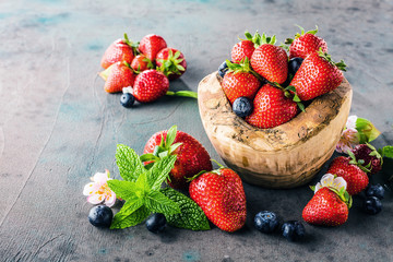Close-up view of fresh blackberries, blueberries, strawberries and green mint leaves
