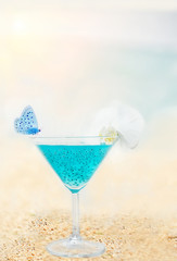 Bright lighting drink with chia seeds in a glass and butterflies by the sea. artistic photo, the atmosphere of a relaxed magical holiday. soft selective focus.