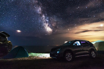 Fototapeta na wymiar Cars and tourist tents at the beach at night