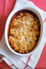 Overhead image of plum cobbler with almond flakes and cream