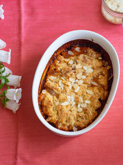 Overhead image of plum cobbler with almond flakes and cream