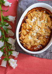 Overhead image of plum cobbler with almond flakes and cream