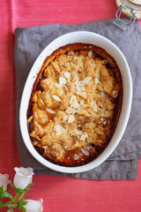 Overhead image of plum cobbler with almond flakes and cream