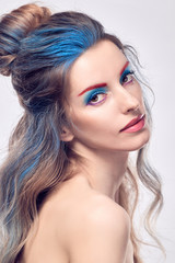 Naklejka premium High Fashion. Beautiful woman with art paint makeup, creative Dyed hairstyle. Gorgeous blonde girl with styling wavy hair, healthy skin. Young model girl, fashionable make up. Creative Beauty portrait