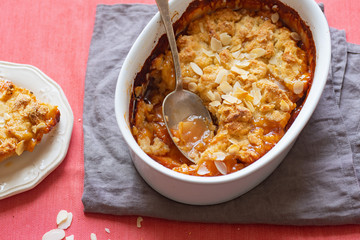 Overhead image of plum cobbler with almond flakes and cream