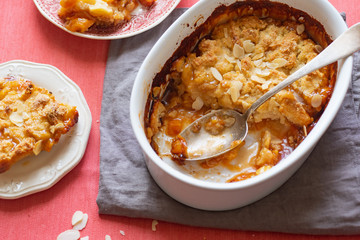 Overhead image of plum cobbler with almond flakes and cream