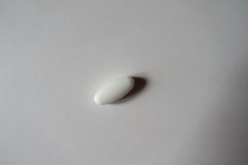 View of one big white oblong caplet of calcium citrate from above