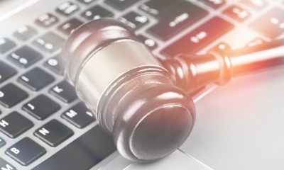 Judge hammer on laptop keyboard, close-up