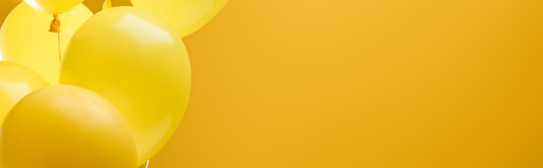 colorful minimalistic decorative balloons on yellow background, panoramic shot