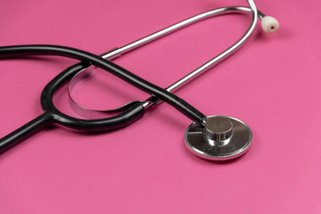 medical stethoscope on pink background. helthcare and cardiology background