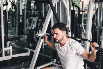 Handsome Sporty Man is Exercising With Lifting Machine in Fitness Club.,Portrait of Strong Man Doing Working Out Calories Burning in Gym Club., Healthy and Sport Fitness Lifestyle Concept.