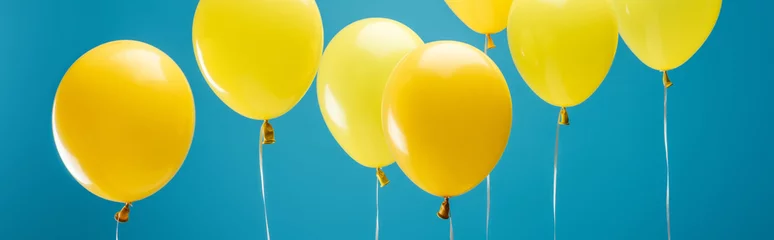 Schilderijen op glas heldere partij gele ballonnen op blauwe achtergrond, panoramische opname © LIGHTFIELD STUDIOS