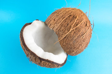 Coconut cut into two pieces. Coconut on blue.