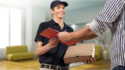 Man delivering package, holding clipboard for signature