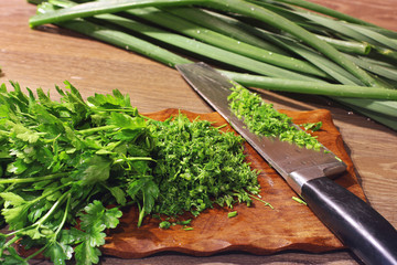 Cooking in the kitchen. Greenery. Green onions. Knife and cutting board