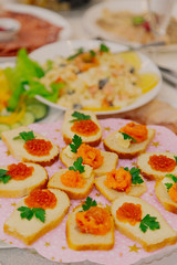 Fresh sandwiches with red caviar on the holiday table.