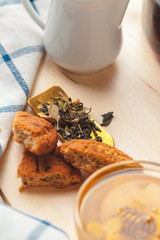 Metal sieve with dried  herbal tea in a glass cup on the background of table
