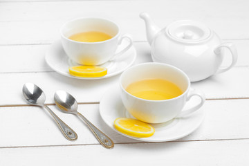 teapot and cups of tea on a white wooden background