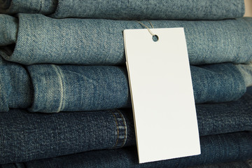 A stack of new jeans with white paper tag mockup