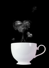 White coffee cup with white smoke, heart shape on a black background