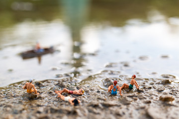 Miniature people wearing swimsuit relaxing on the beach , Summer concept