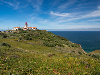 Fototapeta na wymiar Cabo da Roca, Portugal. Lighthouse and cliffs over Atlantic Ocean, the most westerly point of the European mainland. May, 2019