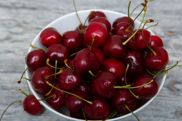 Obraz na płótnie Canvas cherries in white bowl on wooden background