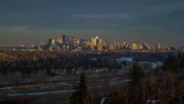 Time-lapse of the City of Calgary as the sunsets, and a long shadow is cast across the city.