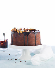 Easy Birthday Drip Cake with melted chocolate ganache with party decor on a white background. Copy space. Celebration concept. Trendy Cake.