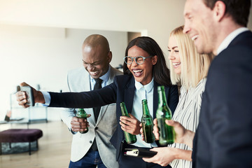 Laughing businesswoman taking selfies over drinks with colleague