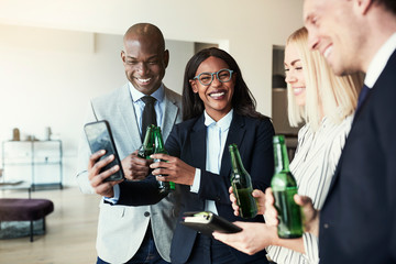 Laughing businesspeople looking at cellphone photos during after