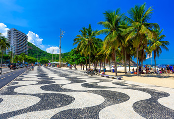 View of Leme beach and Copacabana beach with palms and mosaic of sidewalk in Rio de Janeiro, Brazil
