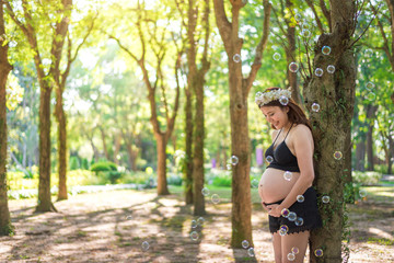 Beautiful pregnant woman relaxing outside in the park