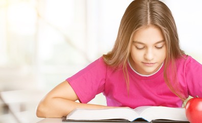 Little student girl studying on background