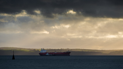 cargo ship under stormy sky