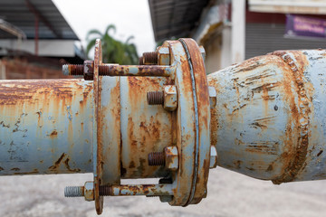 Old blue pipeline with valve on the background of buildings. Copy space