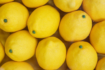 Close Up Of Plastic Yellow Lemons, Laying In Several Rows