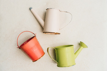 Colorful watering cans and bucket for plants on white background